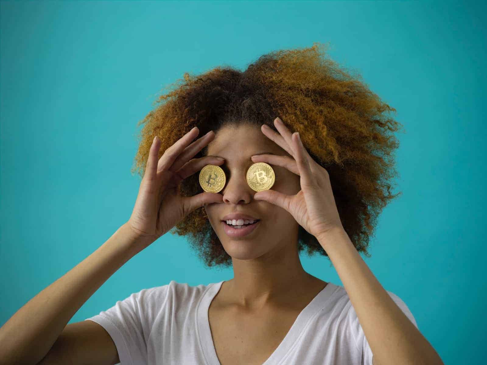 mujer sosteniendo dos monedas redondas de color dorado