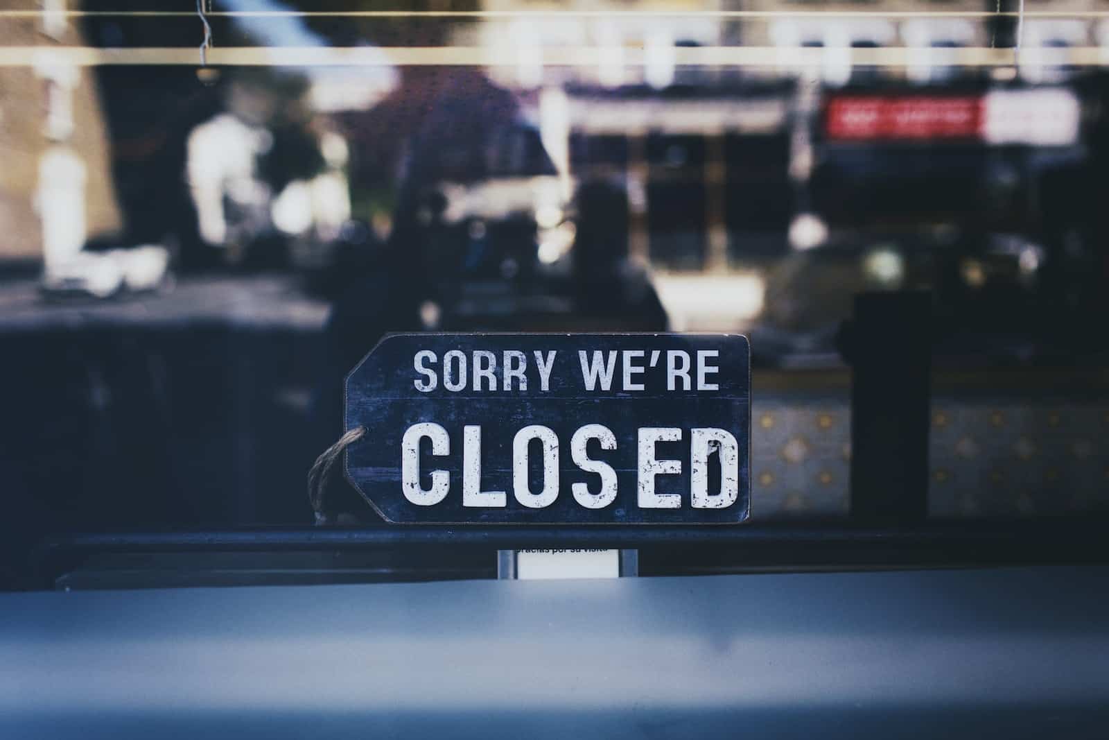 Zdjęcie z bliska, przedstawiające znak „Sorry We're Closed” na szklanym oknie